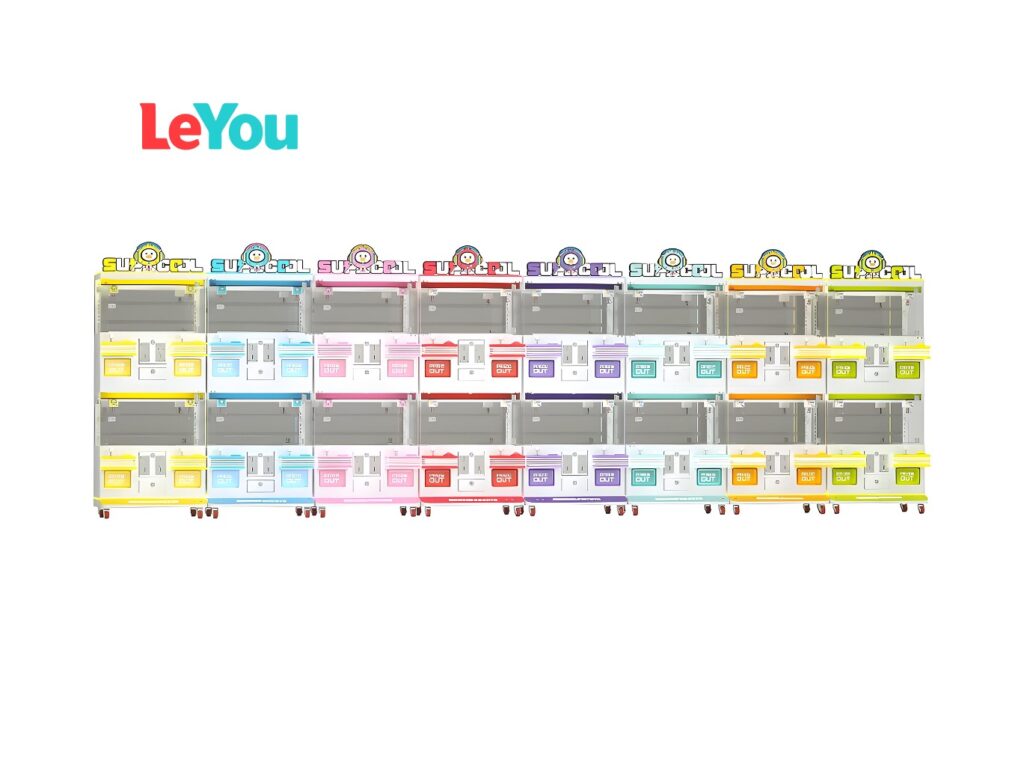 Marque LeYou : Huit distributeurs automatiques colorés dans des boîtiers à rayures arc-en-ciel, chacun avec le logo mascotte " SU-OCCL ", des étagères à produits superposées derrière des portes vitrées, des distributeurs " PICK OUT " et des roulettes de mobilité sur fond blanc.