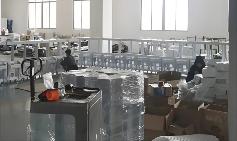 Taller de montaje en la fábrica de Leyou con técnicos instalando armarios para máquinas de garras